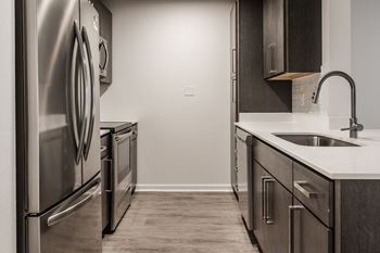 an empty kitchen with stainless steel appliances and a sink at Latitudes Apartments, Indianapolis, IN